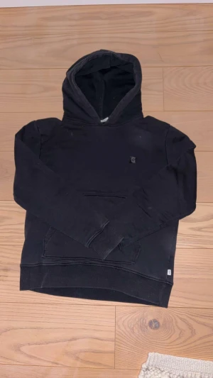 Svart grunt hoodie - Fin svart hoodie från grunt med ganska tajt passform. Storleken är xl barnstorlek men passar lika bra till xs. Säljer för den har blivit för liten för mig. Perfekt stil ren hoodie som passar till allt året om!