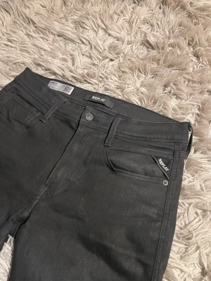 Svarta Replay Jeans  - Svarta Replay Anbass jeans med slim passform.