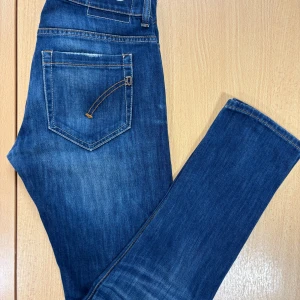 Blåa dondup jeans  - Snygga blå jeans från dondup. Jeansen har kontrastsömmar, fem fickor och en cool tvättad look med lätt slitning. Materialet är robust denim och midjan är normal. Perfekta för dig som gillar stilrena och tidlösa jeans.