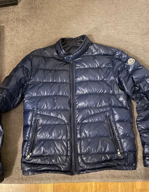 Moncler acorus jacka - Hej säljer nu en blå jacka från moncler i modellen acorus. Den är i bra skick och storlek 5 vilket motsvarar XL, men sitter mer som en M. Passar dig som är 180-185cm lång ungefär. Självklart äkta. Skriv vid frågor eller funderingar. Mvh/ Leo