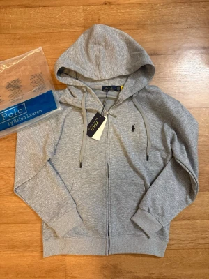 Polo Ralph Lauren Zip Up Hoodie - En jättefin kofta från Polo Ralph Lauren i nyskick. Priset kan diskuteras så tveka inte att höra av dig eller ifall du har frågor! Storlek M men kan passa S bättre.