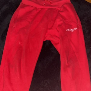 Röda mjukisbyxor från McKenzie - Röda mjukisbyxor från McKenzie med vit logga på ena benet. Byxorna har resår och snörning i midjan samt mjukt material som är perfekt för chill eller träning. Klassisk passform och bekväm stil.Ny pris runt 400 