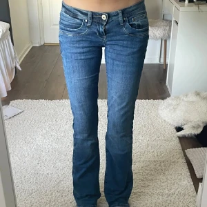 Blå bootcut jeans från LTB - Snygga blå jeans från LTB med bootcut passform och klassiska fem fickor. Jeansen har låg midja, kontrastsömmar och är tillverkade i mjukt denimtyg. 26/32
