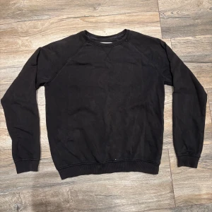 Svart sweatshirt från Pier One - En stilren svart sweatshirt från Pier One med klassisk rund halsringning och ribbade muddar vid ärmslut och nederkant. Tröjan är tillverkad i mjuk bomull och har en enkel, clean look som passar perfekt till jeans.