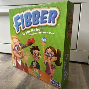 Fibber - Ett roligt och färgglatt spel där du ska tänja på sanningen – men akta dig, för din näsa kan växa! Perfekt för kompisgänget eller familjen, och passar alla från 7 år och uppåt. Utmana dina vänner och se vem som kan bluffa bäst!