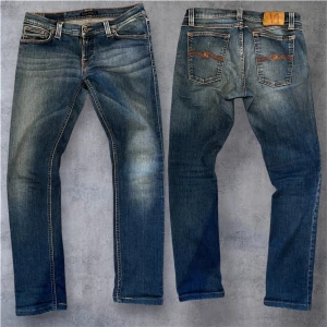 Nudie Jeans Long john 31/34 - Säljer ett par klassiska blå jeans från Nudie Jeans med snygga slitningar och kontrastsömmar. Jeansen har fem fickor, orange broderi på bakfickorna och en skinnpatch i midjan. Perfekt passform och riktigt skön denimkänsla.