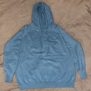 Blå hoodie i bomull  - Säljer en snygg blå hoodie i bomull . Den har en skön passform med långa ärmar och ribbade muddar. Perfekt för höst och vår när du vill vara både bekväm och stilren. Huvan har dragsko för justering. Perfekt för chill dagar eller en promenad i parken.