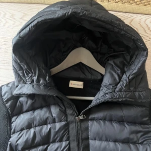 Moncler cardigan - Säljer denna svarta moncler cardigan. Personen på bilden är 180 cm. Jackan är bra skick. Skriv privat vid frågor