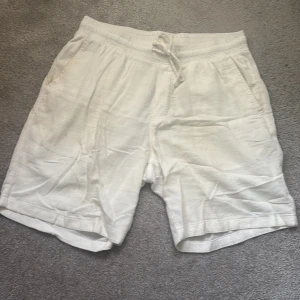 Vita bomulls shorts från Jack & Jones - Snygga vita shorts från Jack & Jones . De har elastisk midja med snörning, sidfickor och en bakficka. Perfekta för varma dagar när du vill ha en clean och fräsch look.