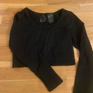 Svart croppad långärmad tränings topp - En svart, croppad långärmad tränings topp