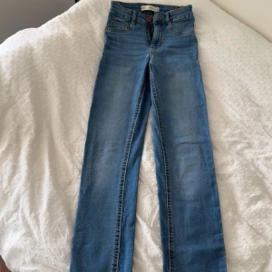 Blå Molly jeans från Gina Tricot XS - Snygga blå Molly jeans från Gina Tricot i storlek XS. Jeansen är högmidjade med klassisk femficksdesign och dragkedja. De har en slim passform och är tillverkade i stretchigt denim för en bekväm känsla. Perfekta till din vardagsstil.