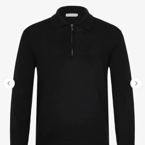 Svart stickad half zip-tröja Tiger of Sweden - Svart stickad tröja från Tiger of Sweden med klassisk krage och half zip-dragkedja framtill. Långärmad modell i mjukt material som ger en clean och stilren look. Perfekt för dig som gillar minimalistisk stil och vill ha något som funkar året runt.