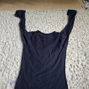 Mörkblå långärmad tröja i bomull - En enkel och stilren mörkblå långärmad tröja i mjuk bomull. Tröjan har rund halsringning och en smal passform som sitter snyggt på kroppen. Perfekt att bära som basplagg eller under en hoodie.