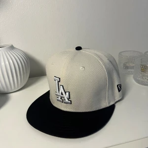 LA Keps Svart och Vitt Strl 55,8 - Säljer en fet Svart och Vitt LA Keps som är storlek 55,8