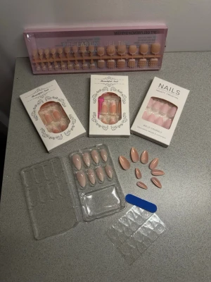 Press-on naglar i nude och rosa toner - Flera set press-on naglar i nude och rosa nyanser, både mandelformade och fyrkantiga.  Långa förpackningen längst bak är till fötterna, sedan är det 4st till händerna. Den jag lagt ut innehåller 24st tippar. Inkluderar gel tips, limkuddar och en liten nagelfil. Perfekt för dig som vill ha snygga naglar snabbt och enkelt.