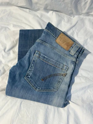 Dondup blå jeans slim fit - Snygga blå dondup jeans med klassisk femficksdesign i slim fit. Jeansen har en ljus tvätt med subtila slitningar och är tillverkade i mjuk bomullsdenim. Perfekta för en avslappnad och trendig look.
