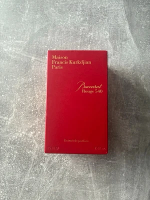 Maison Francis Kurkdjian Baccarat Rouge 540 - Lyxig parfym från Maison Francis Kurkdjian, Baccarat Rouge 540 Extrait de Parfum. Kommer i en elegant röd kartong med gulddetaljer och illustration av byggnad på sidan. Flaskan innehåller 70 ml och doften är känd för sin exklusiva och unika karaktär.