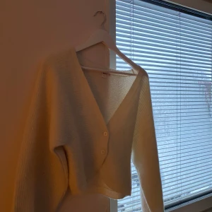 Krämvit kofta från Gina Tricot - Mysig krämvit kofta från Gina Tricot med v-ringning och två knappar framtill. Koftan är stickad i ett mjukt material. Nästintill aldrig använd och därför säljs den!💕Bara att skriva vid fler frågor eller bilder🩷Storlek 158/164 men passar mig som har XS/S! Pris kan diskuteras