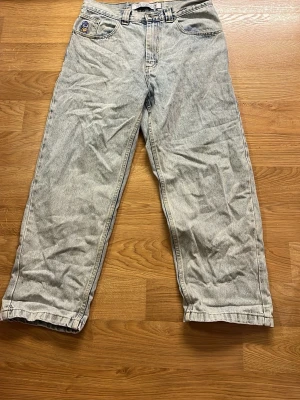 Polar skate ( junk yard) ljusa raka jeans -  ljusa blåa polar skate jeans med rak passform och femficksdesign. Jeansen har en ikonisk patch bak och knappgylf. Perfekta för en avslappnad och tidlös stil. Tillverkade i slitstarkt denimtyg. Storlek 30/30.