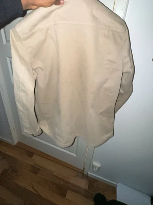 Overshirt från Oscar Jacobson  - En beige stilren overshirt ifrån Oscar Jacobson använd 1-2 gånger, köpt för 2500kr, kvitto finns skriv om det finns mer funderingar! 