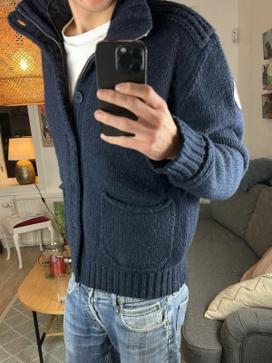 Stickad cardigan mörkblå  - Trendig och stilren perfekt nu i vinter. Mått: A:54 B:51 C:48 D:66 (cm)  storlek m/l. Skriv vid fundering 😇