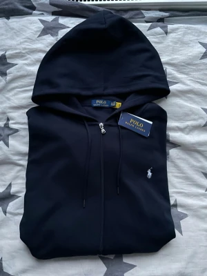 Polo Ralph Lauren kofta - Polo Ralph Lauren kofta med vit logga.  Fick den i present men den blev aldrig använd. Har endast legat hemma.  Skick: helt ny / oanvänd.