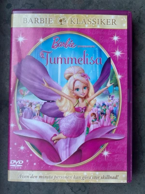 Barbie Tummelisa dvd - DVD-film Barbie presenterar Tummelisa. Animerad barnfilm.  Finns på språk: Svenska, Engelska, Finska   OBS!! skivorna är begagnade så det kan förekomma repor/hairlines på skivorna, men då jag kollar igenom alla filmer jag säljer garanterar jag att alla funkar felfritt om inget annat står! :)