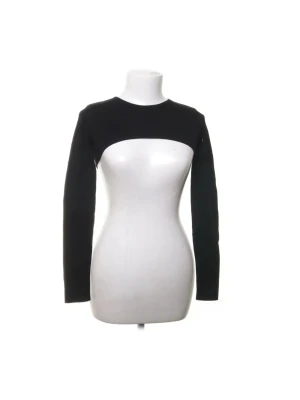 Svart croppad bolerotopp - Säljer en svart bolerotopp med långärmad design och croppad passform. Toppen har en öppen front som visar magen och är perfekt för att styla över linnen eller klänningar!