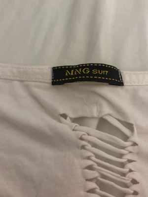 Vit långärmad topp från Gina Tricot - Vit långärmad t-shirt från Gina Tricot med fyrkantig urringning. Tillverkad i mjuk bomull och har en clean look utan mönster. Perfekt för dig som gillar basic men ändå vill ha en snygg passform.