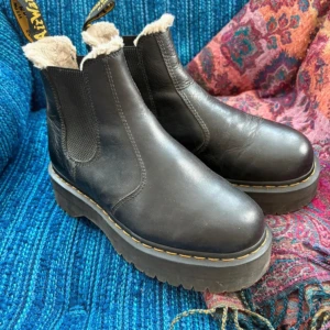 Svarta Dr. Martens chelsea boots - Snygga och rejäla Dr. Martens Chelsea - inspirerade platåboots med mjuk fuskpäls på insidan. Mycket gott skick! Säljs pga att de inte kommer till användning.   STRL: 39   Hör av dig vid frågor! 💘 