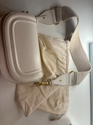 Vit axelväska  - Jättesöt axelväska från Zara, använd några gånger men ser fortfarande helt ny ut. Ligger kvar i din ordinarie påse! Den har en förlängd band som man kan sätta på 