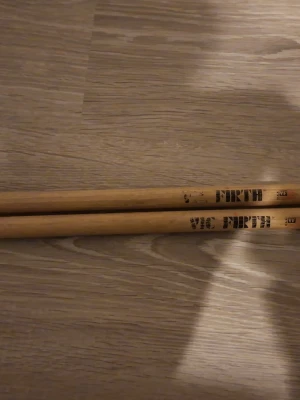 Ingen väst på bilderna - Det är ett par riktigt bra trumstockar från Vic Firth, modell American Classic Extreme 5B. Lite slagmärken från trummorna men det stoppar dom inte 