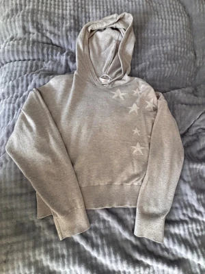 Storlek 134/140 - Jätte fin tynnre hoddie i storlek 134/140. Använd några gånger. Den har vita stjärnor i vänstra hörnet.