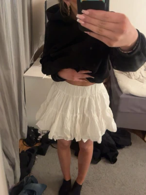 Vit volangkjol från H&M, storlek 36 - Supersöt vit kortkjol från H&M i storlek 36. Kjolen har bred resår i midjan och flera lager volanger som ger en fluffig känsla. 