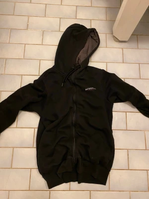 Mckenzie hoodie  - Jag säljer en Mckenzie hoodie som är svart och har storlek M den har en luva två snören vid halsen och två fickor plus Mckenzie märket på vänstra bröstet 