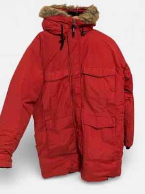 Röd parkas från Gant med fuskpäls - Säljer en röd parkas från Gant med huva och fuskpälsdetalj. Jackan har fyra stora fickor framtill, broderad logga på ärmen och dragkedja framtill. Perfekt för kalla dagar och riktigt snygg oversized look.