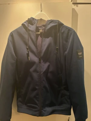 Säljer en softs hell jacka från Jack and Jones  - Den har en luva med två snören. 