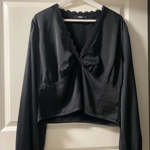 Svart blus med spets från Bik Bok - Säljer denna snygga svarta blusen från Bikbok. Storlek XL men skulle säga att den e mindre i storleken, passar mig som har M. 