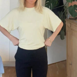 Ljusgul t-shirt från 157, storlek M - Snygg blekgul t-shirt från 157 i storlek M. Modellen har en loose passform med korta ärmar och rund halsringning. Materialet är mjuk bomull