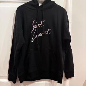 Svart Saint Laurent Hoodie  - FÄRG Saint Laurent Hoodie. Storlek: L, sitter mer som M. Skick: 9/10. Fraktar inom 24 timmar. Fråga på!