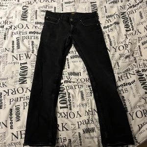Svarta Lee jeans Blake W30 L32 - Snygga svarta jeans från Lee i modellen Blake. Klassisk femficksdesign med raka ben och normal passform. Jeansen är tillverkade i bomull och har diskreta sömmar och Lee-logga i linningen. Perfekta för dig som gillar stilrena och tidlösa jeans.