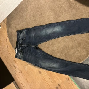 Replay - Snygga Replay Hyperflex jeans i mörkblå tvätt med lätt slitning på låren. Klassisk femficksmodell med stretchigt material för extra komfort. Skinnpatch med Replay Hyperflex på bakfickan och kontrastsömmar. Perfekta för dig som gillar en modern och bekväm look.