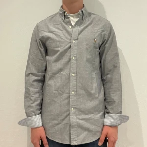 Grå Ralph Lauren skjorta - Grå Ralph lauren skjorta || Storlek S (Slim fit) || Skjortan är i bra skick || modellen på bilden är 170cm och väger 62kg || Tveka inte på att höra av dig vid frågor eller funderingar 