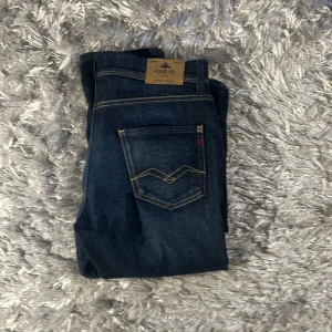 Replay jeans mörkblå straight fit - Snygga mörkblå jeans från Replay med klassisk femficksdesign och kontrastsömmar. Modellen har rak passform och normal midja, med Replay-logga på fickan och bak på linningen. Tillverkade i slitstarkt jeanstyg som sitter skönt hela dagen.