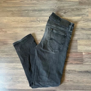 Svarta skinny jeans från Lee - Snygga svarta jeans från Lee med diskret tvättad look och klassiska fem fickor. Jeansen har Lee-logga på bakfickan och svart patch i midjan. Perfekta för en stilren och avslappnad outfit. W 30 L 34. Pris kan diskuteras!