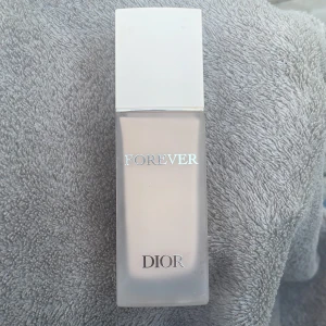 Dior Forever Foundation 00,5N - Dior Forever Foundation i nyansen 00,5N. Ljus, neutral ton med hög täckning och matt finish. Kommer i en lyxig, frostad glasflaska med vit plastkork och silverdetaljer. Innehåller SPF 20 och håller i 24 timmar utan att smeta av sig.