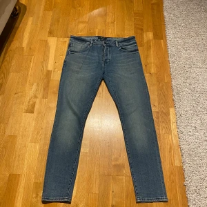 Neuw slim fit jeans - Snygga blå jeans från Neuw med klassisk femficksdesign och slim passform. Jeansen har en mörk tvätt med lätt slitning. 
