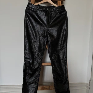 Svarta byxor  - Snygga svarta byxor från ONLY med blank skinn finish och klassisk femficksdesign. Byxorna har rak passform, normal midja och dragkedja med knapp framtill. Används lite loose i st 38 - tightare i st 40.  