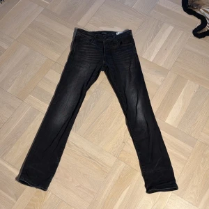 Svarta slim jeans Jack & Jones - Svarta jeans från Jack & Jones, modell Slim/Glenn. Jeansen har en smal passform med klassisk femficksdesign och subtila slitningar. Tillverkade i stretchig denim för extra komfort. Perfekta för dig som gillar en stilren och modern look. Skriv vid funderingar och pris kan diskuteras🤗. W28 L30