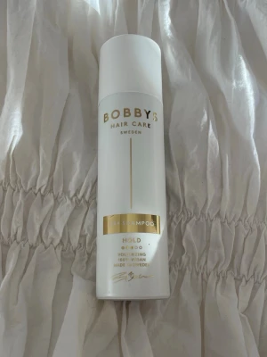 Bobbys Hair Care torrschampo - Torrschampo från Bobbys Hair Care i en vit och guldig flaska. Ger volym och stadga till håret. Svensktillverkat och passar perfekt för att fräscha upp håret mellan tvättar. Endast testad!
